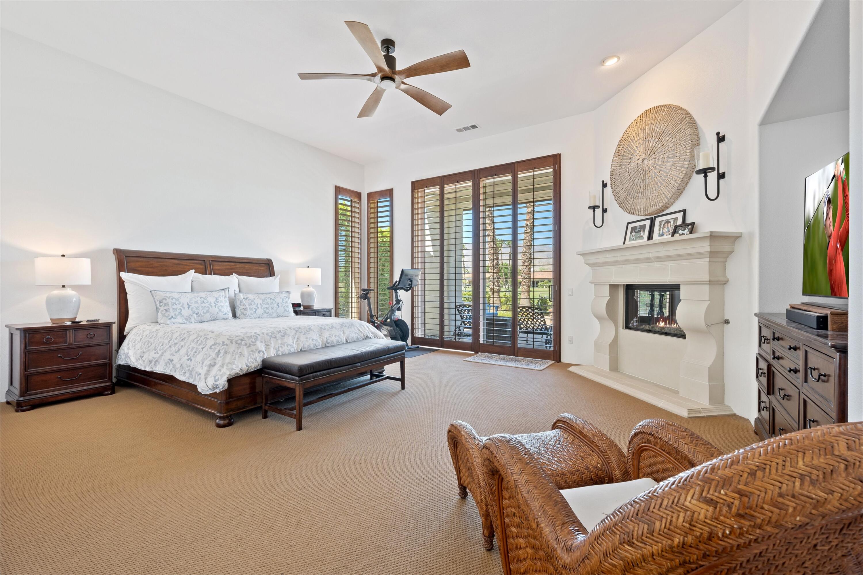56023 Winged Foot La Quinta, CA 92253 - Photo 31 of 44 a spacious bedroom with a bed a couch and a chandelier