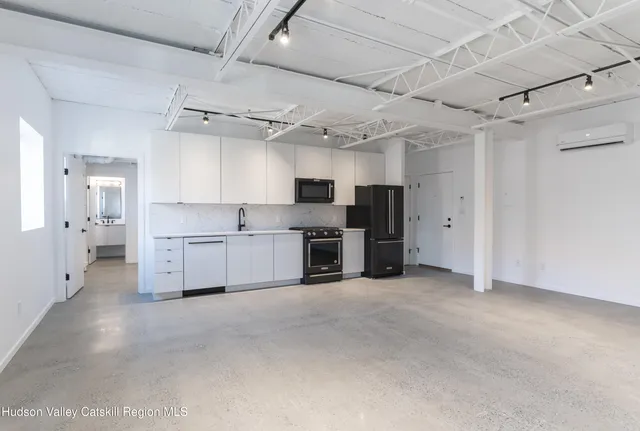 a view of a kitchen with stainless steel appliances a sink and a refrigerator