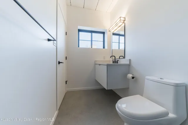 a bathroom with a sink toilet and window