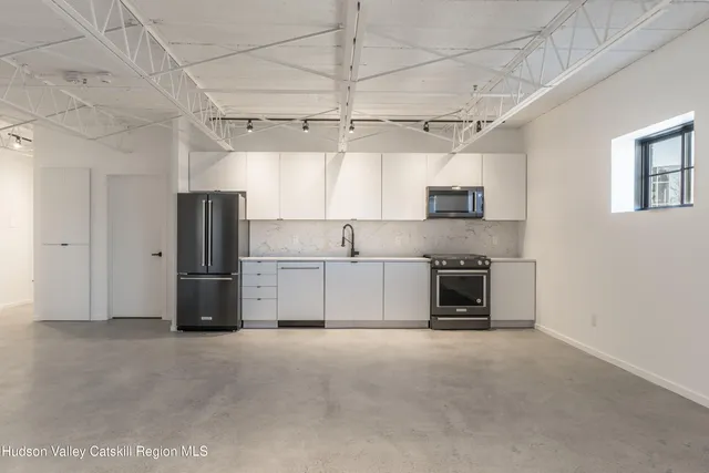 a view of a kitchen with a sink and a refrigerator