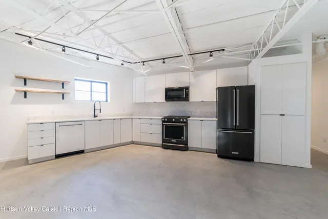 a kitchen with stainless steel appliances a refrigerator sink and white cabinets