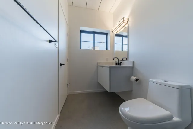 a bathroom with a sink toilet and window