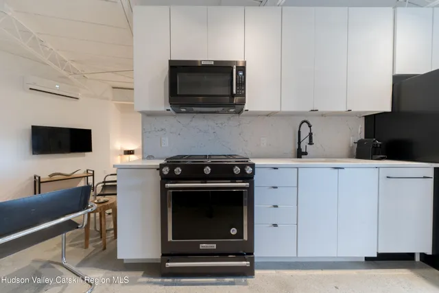 a kitchen with stainless steel appliances a stove a microwave a sink and cabinets