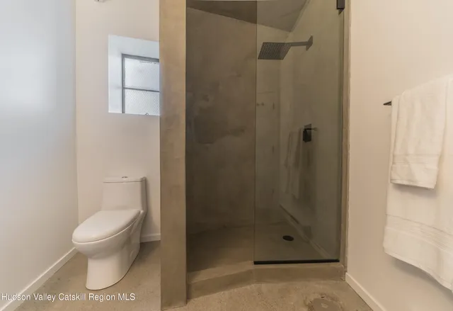 a bathroom with a toilet and a shower