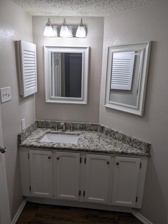 6108 Abrams Road, Unit 325 Dallas, TX 75231 - Photo 12 of 13 a bathroom with a granite countertop sink and mirror
