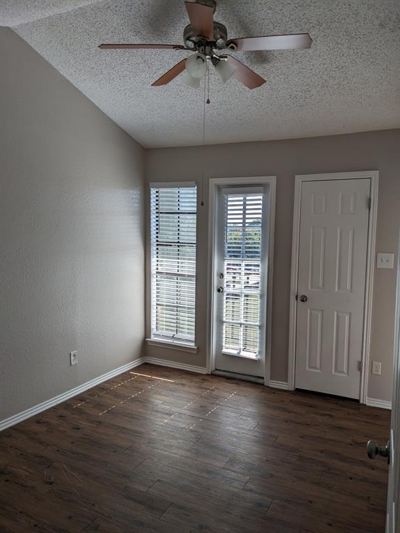 6108 Abrams Road, Unit 325 Dallas, TX 75231 - Photo 5 of 13 an empty room with wooden floor fan and windows