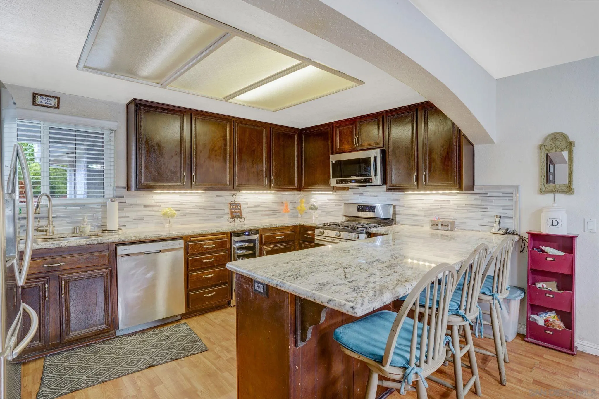 1082 Fulton Road San Marcos, CA 92069 - Photo 12 of 38 a kitchen with granite countertop a stove a sink a dining table and chairs