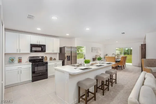a kitchen that has a sink a stove and chairs