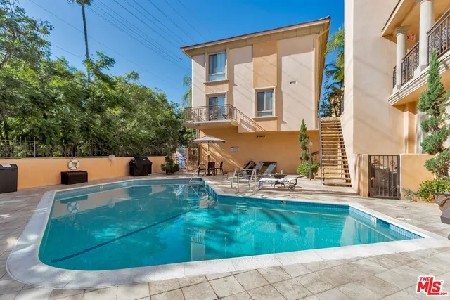 a view of a house with backyard sitting area and swimming pool