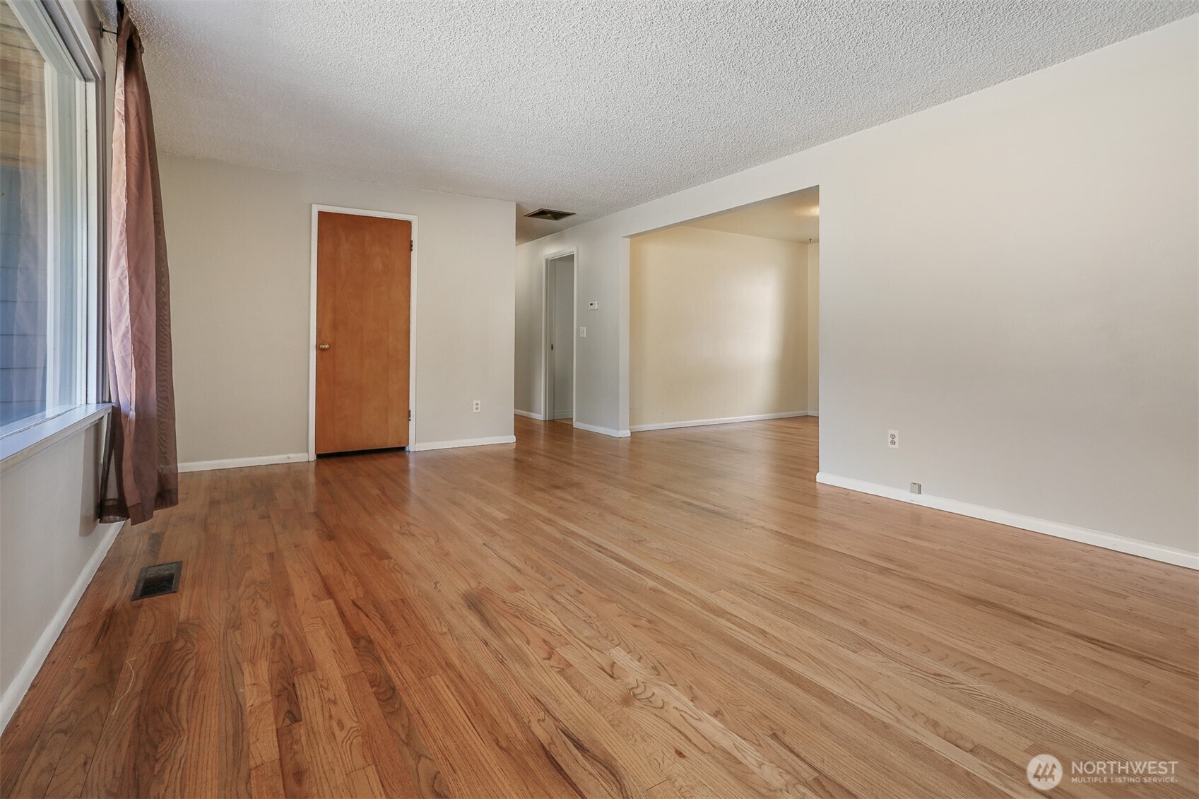 5626 Beverly Lane Everett, WA 98203 - Photo 4 of 38 a view of an empty room with wooden floor and a window