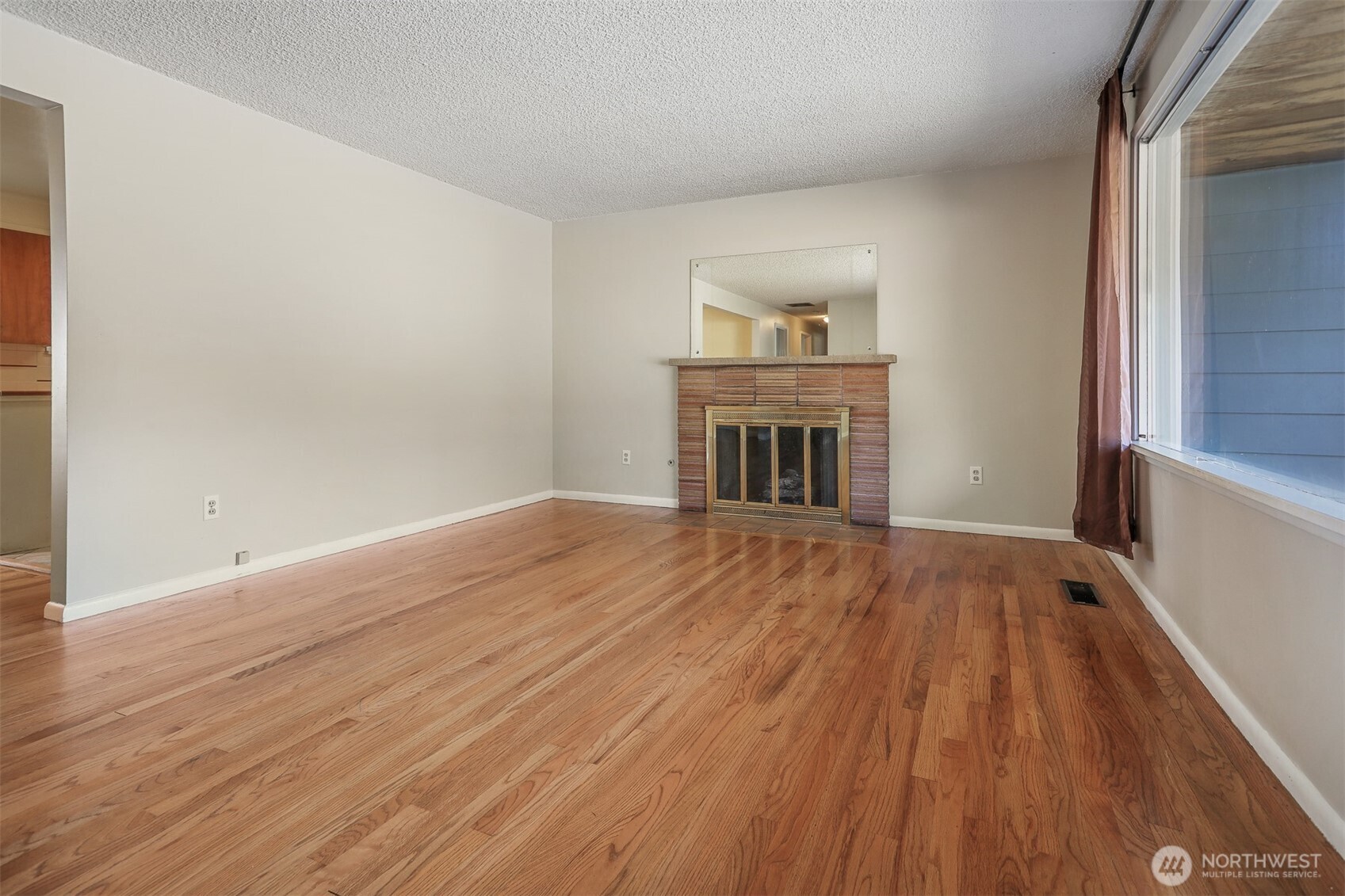 5626 Beverly Lane Everett, WA 98203 - Photo 6 of 38 a view of empty room with wooden floor and fireplace