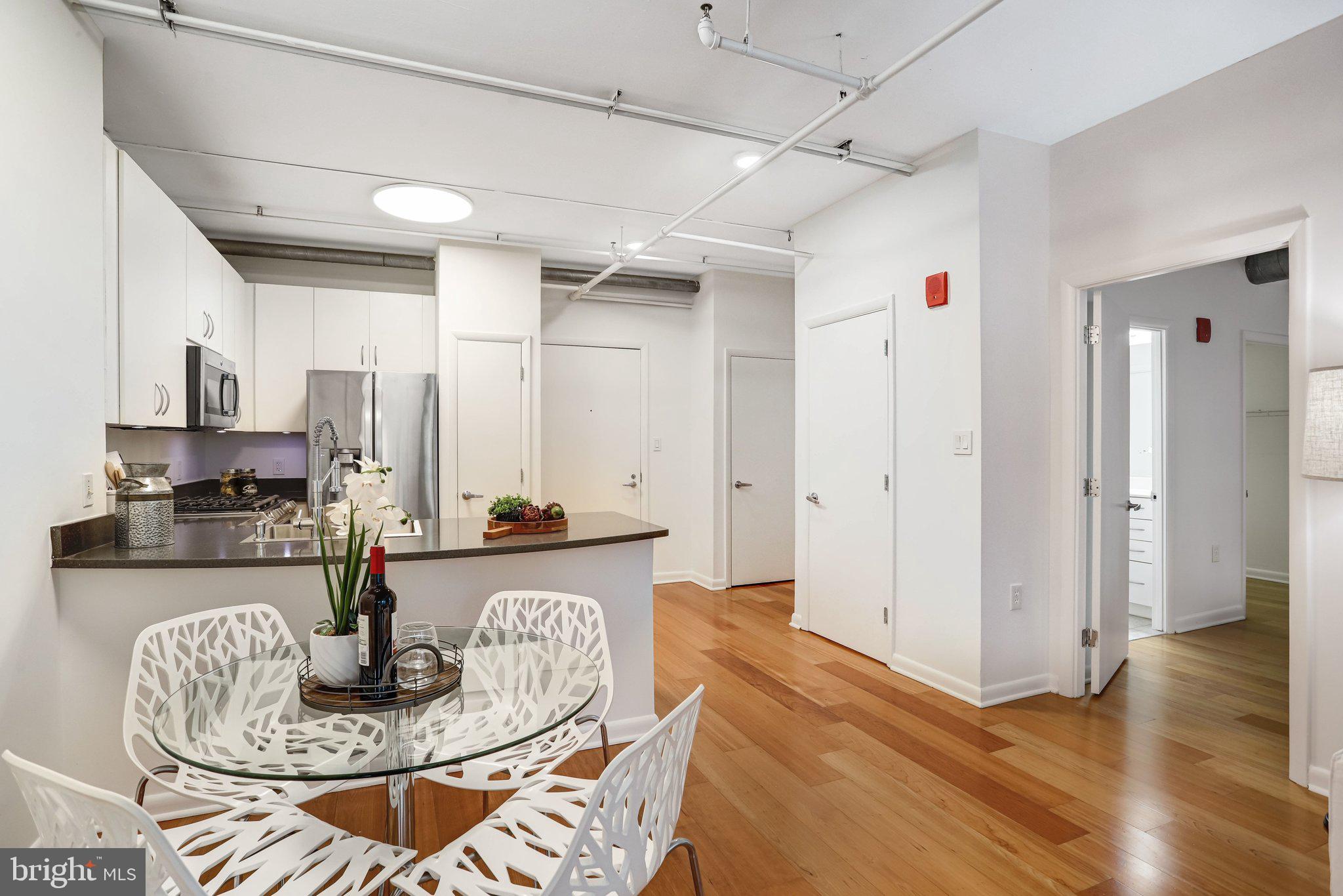 1300 N Street Northwest, Unit 15 Washington, DC 20005 - Photo 15 of 51 a kitchen with granite countertop a table and chairs