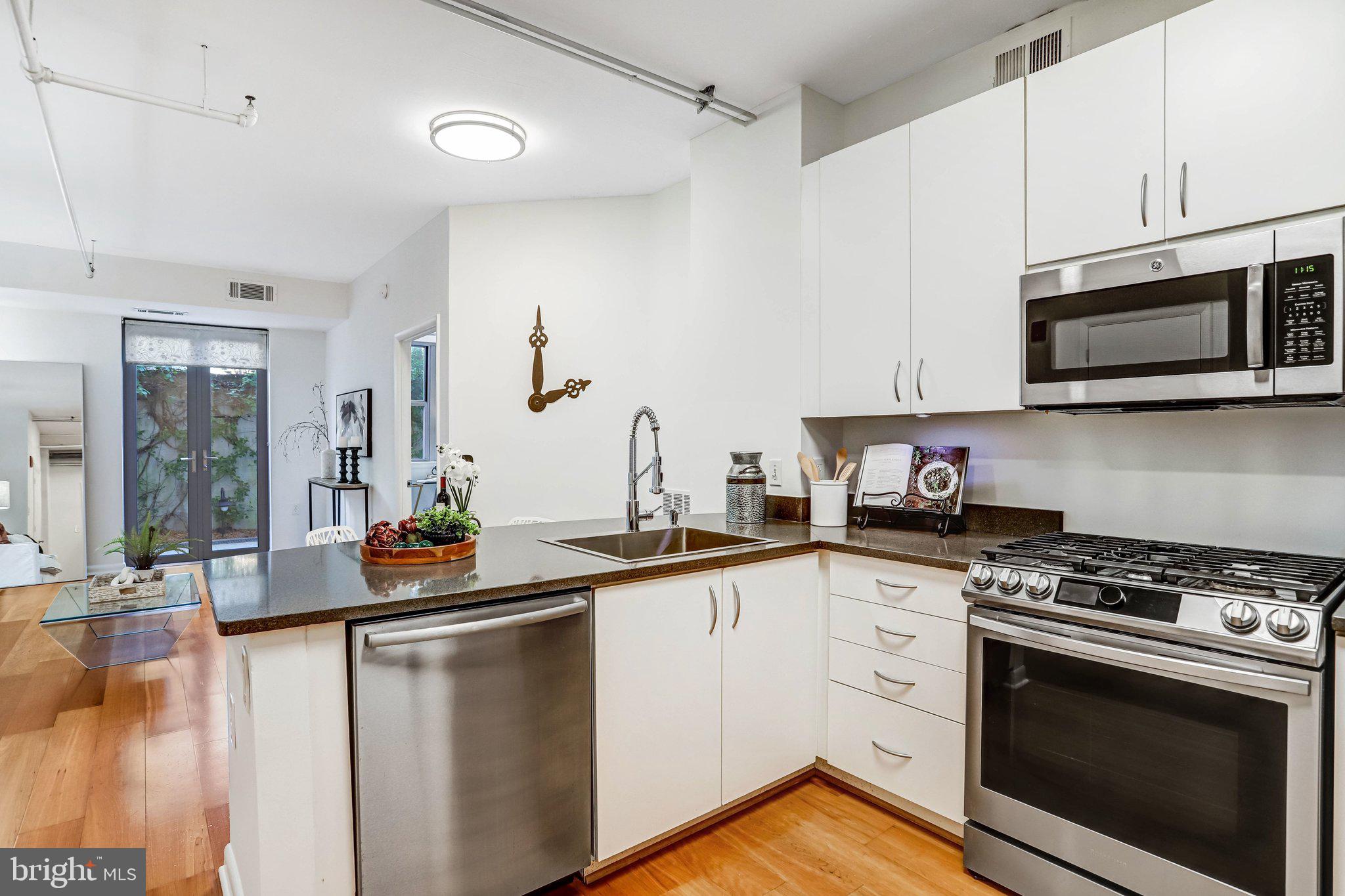 1300 N Street Northwest, Unit 15 Washington, DC 20005 - Photo 17 of 51 a kitchen with stainless steel appliances a stove microwave and sink