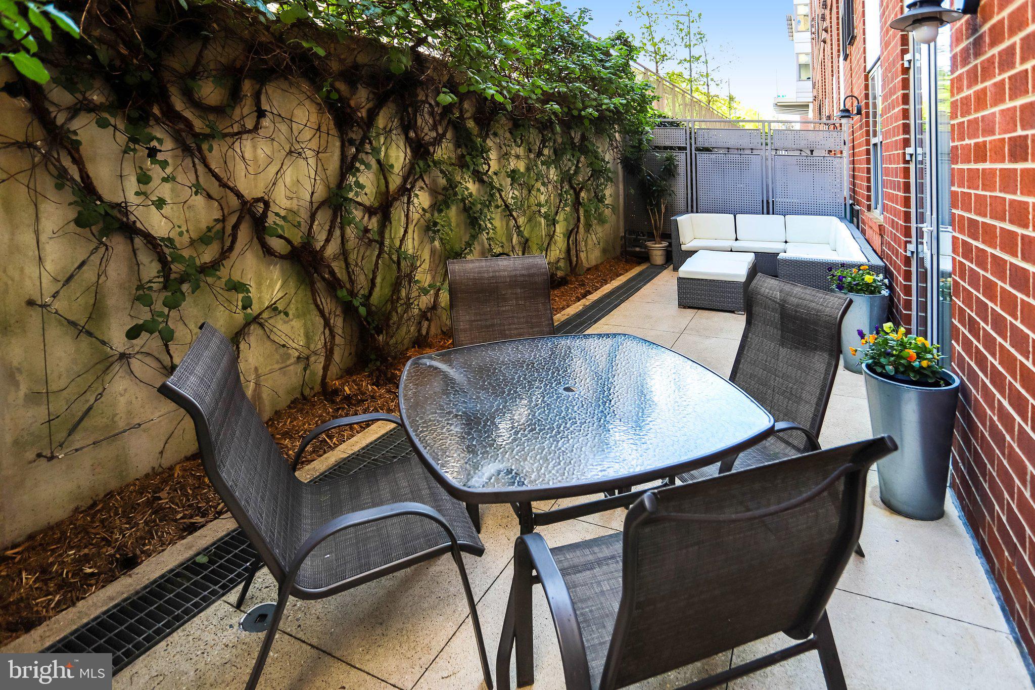 1300 N Street Northwest, Unit 15 Washington, DC 20005 - Photo 32 of 51 a backyard of a house with table and chairs