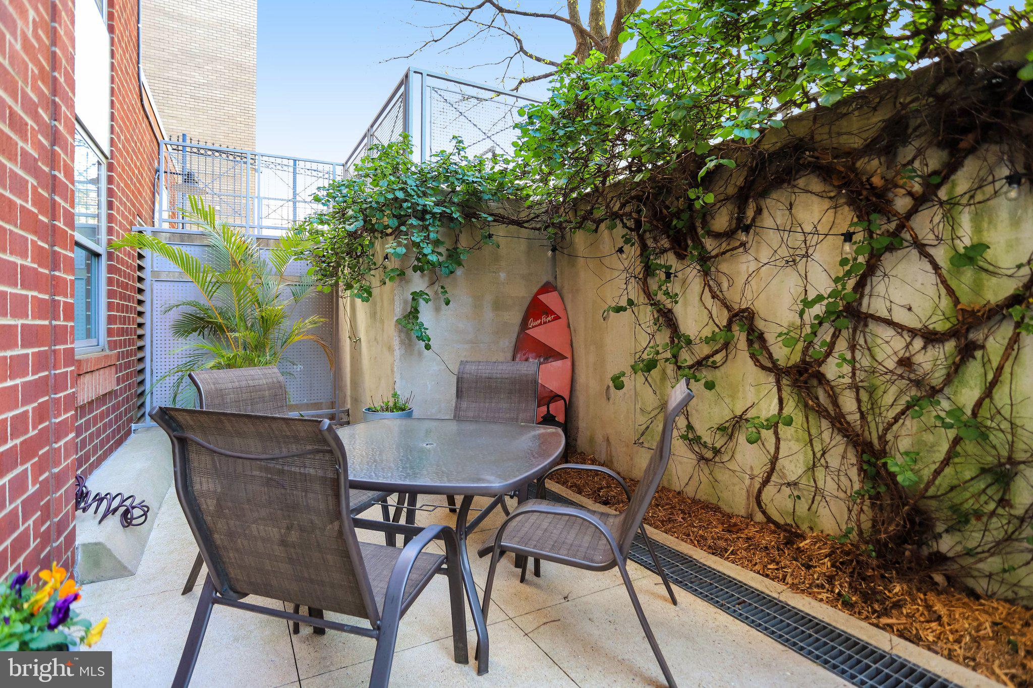 1300 N Street Northwest, Unit 15 Washington, DC 20005 - Photo 33 of 51 a backyard of a house with table and chairs