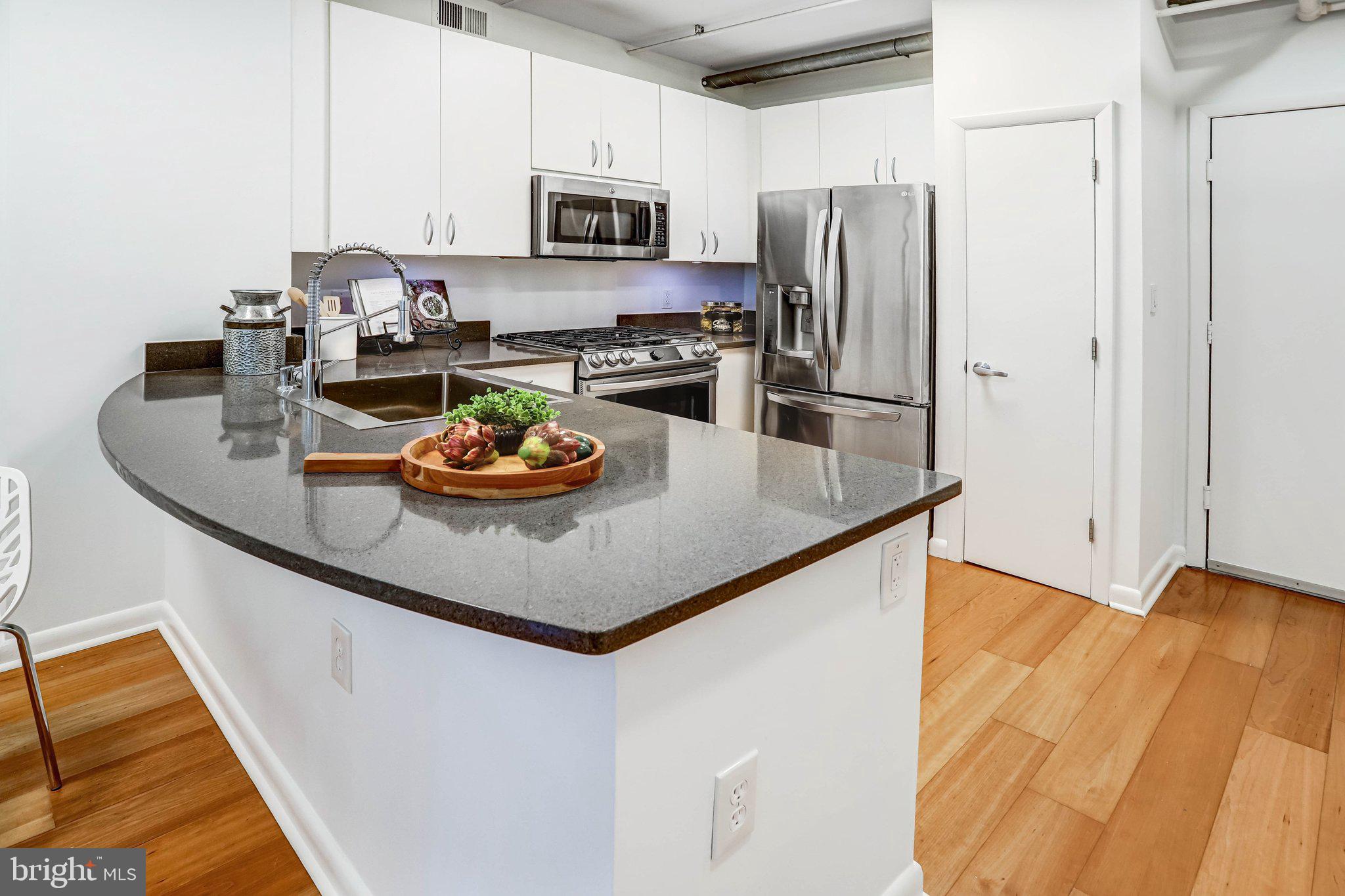 1300 N Street Northwest, Unit 15 Washington, DC 20005 - Photo 7 of 51 a kitchen with stainless steel appliances granite countertop a sink a stove and a refrigerator