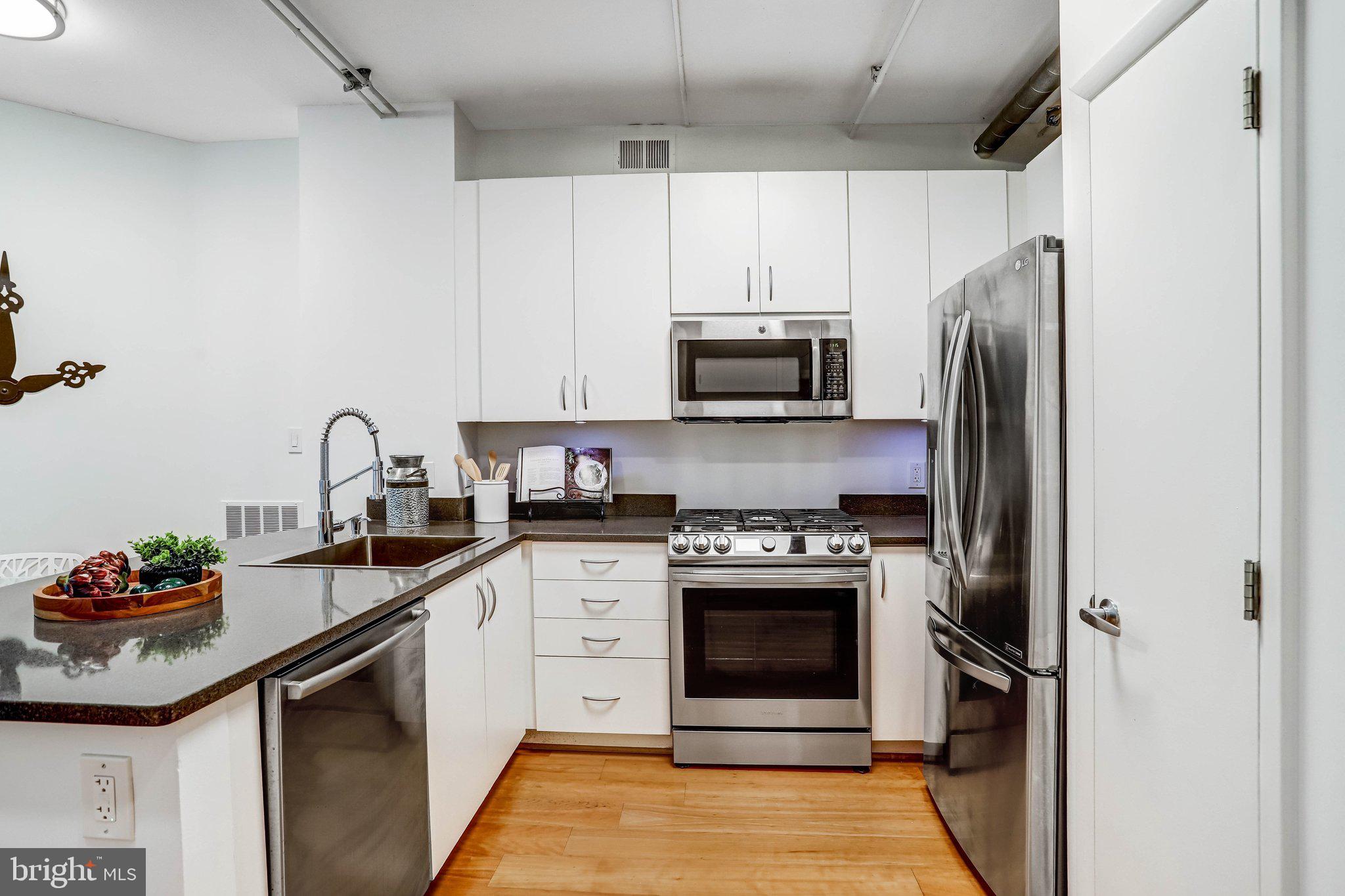 1300 N Street Northwest, Unit 15 Washington, DC 20005 - Photo 8 of 51 a kitchen with stainless steel appliances granite countertop a stove sink and refrigerator