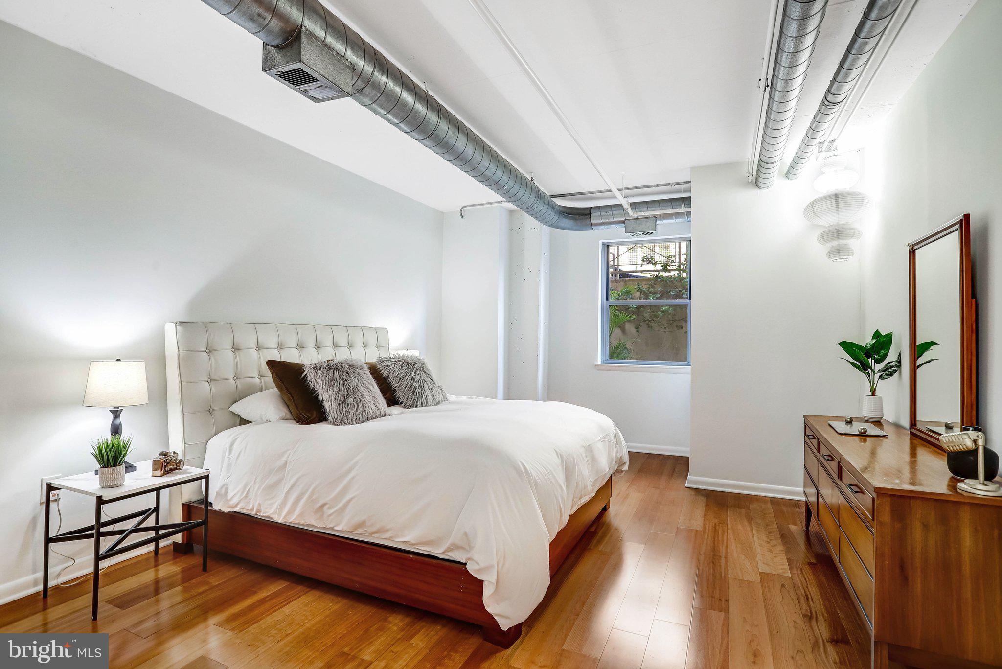 1300 N Street Northwest, Unit 15 Washington, DC 20005 - Photo 10 of 51 a bedroom with a bed and wooden floor