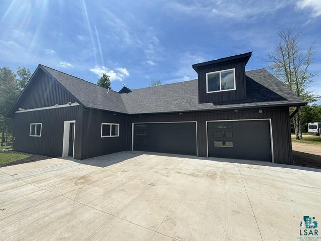 3454 Anderson Road Hibbing, MN 55746 - Photo 2 of 31 Dark-toned exterior featuring vertical siding and a dormer with white-framed windows