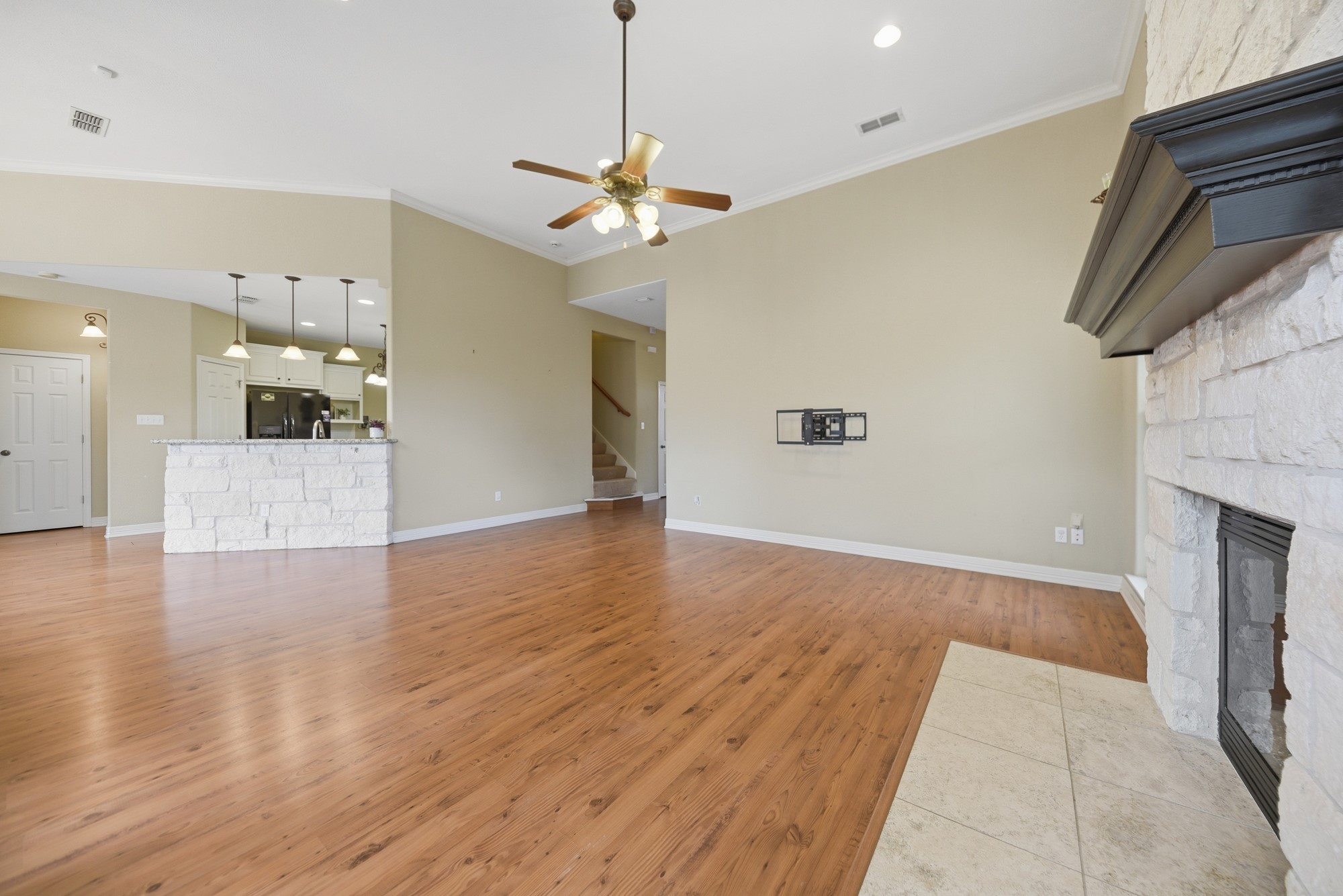 350 Owl Creek Road Giddings, TX 78942 - Photo 28 of 29 a view of a kitchen with a stove a kitchen island wooden floor ceiling fan and a kitchen view