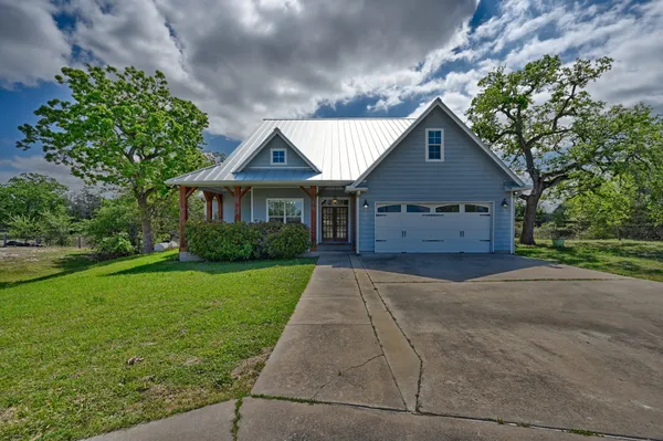 a large kitchen with kitchen island a large counter top space a sink stainless steel appliances and cabinets