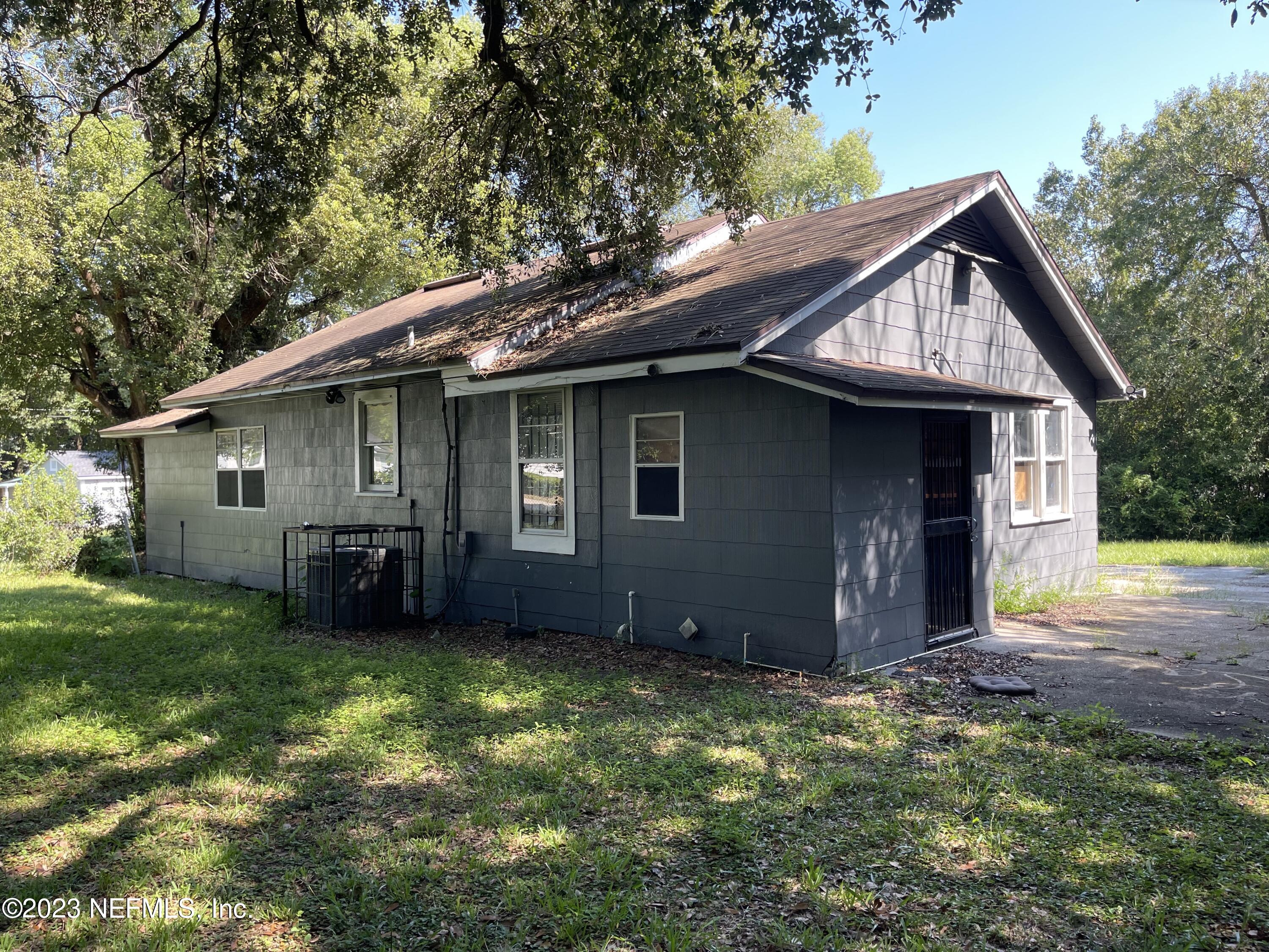 1124 Kenmore Street Jacksonville, FL 32208 - Photo 3 of 11 a front view of house with yard and trees all around