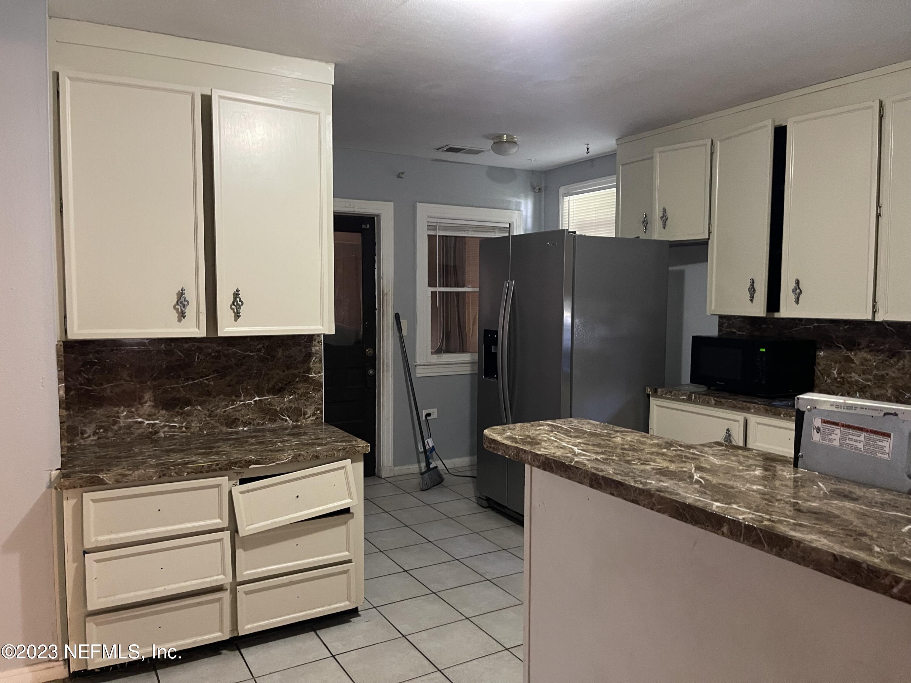 1124 Kenmore Street Jacksonville, FL 32208 - Photo 9 of 11 a kitchen with granite countertop a refrigerator and a stove