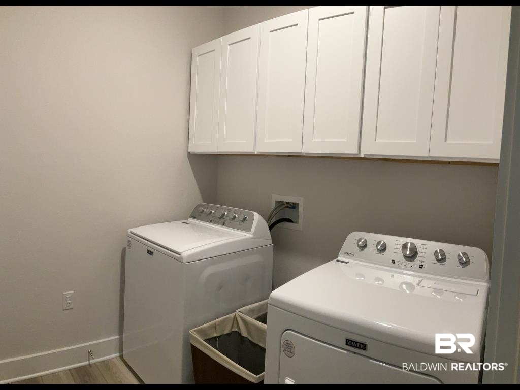 1093 Pheasant Circle Foley, AL 36535 - Photo 23 of 25 Laundry area with cabinet space, wood finished floors, and washer and dryer