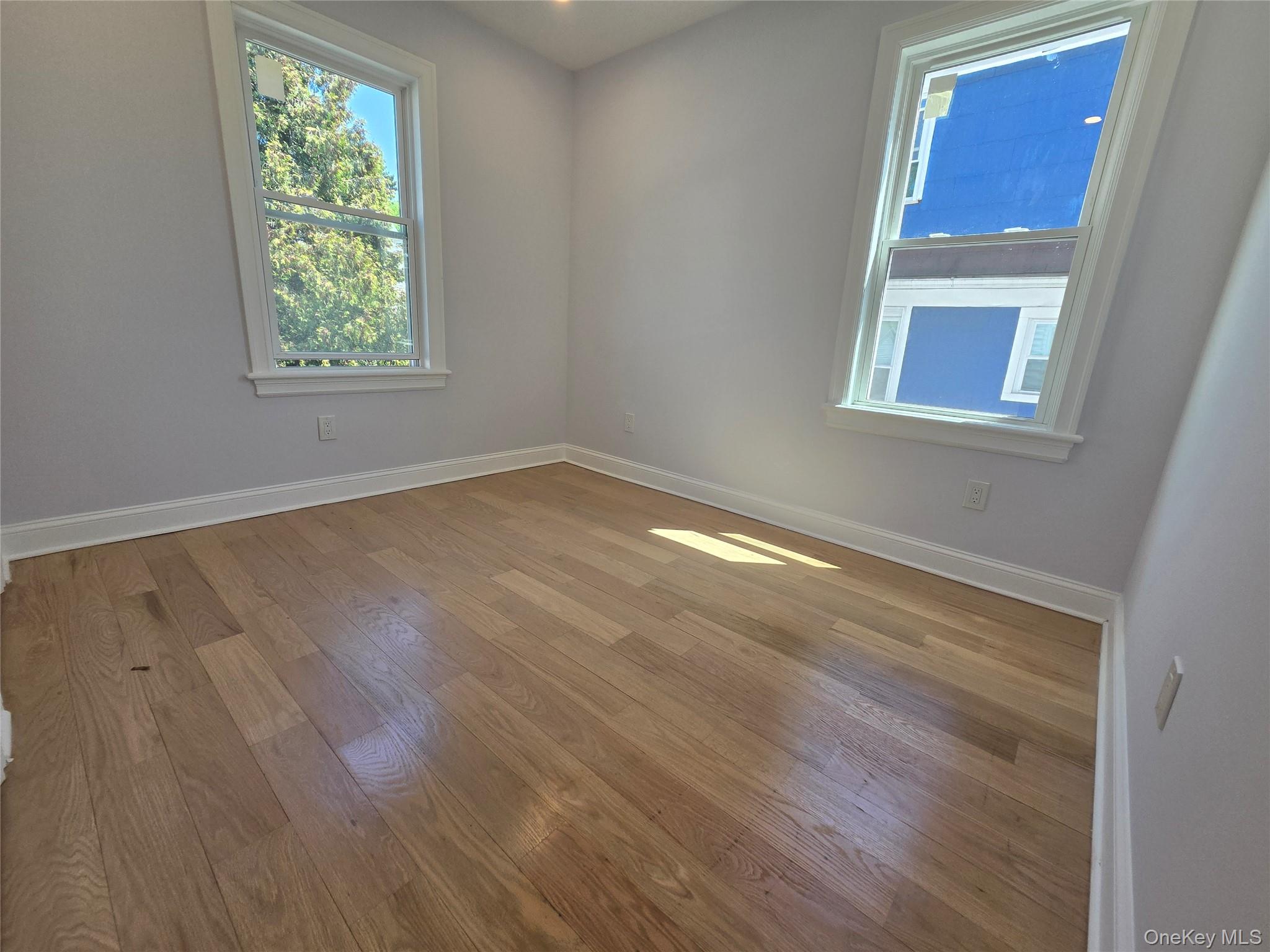 965 Main Street, Unit 2 New Rochelle, NY 10801 - Photo 8 of 12 Room featuring light-toned wood flooring and two windows with white trim