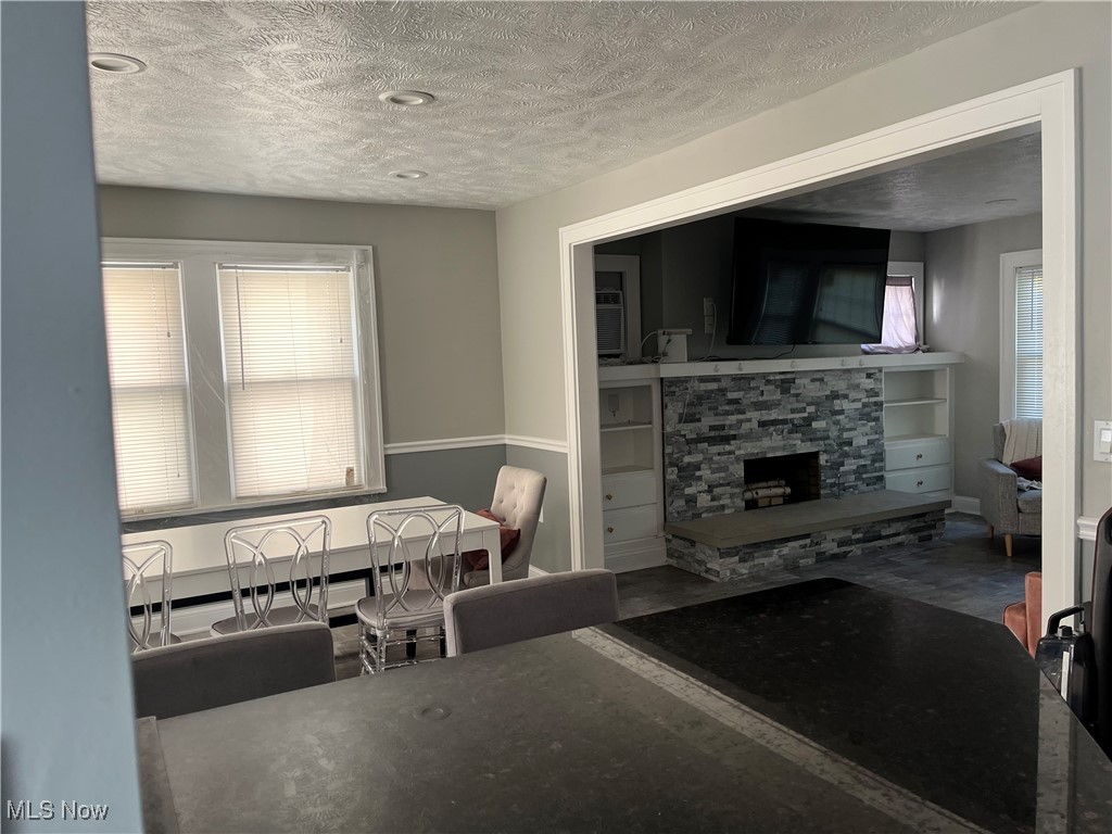 1048 Pembrook Road Cleveland, OH 44121 - Photo 6 of 26 Living room featuring a stone fireplace and a textured ceiling
