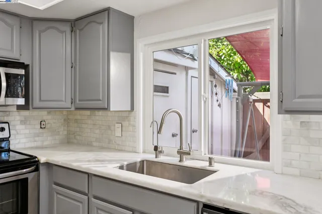 a kitchen with granite countertop a sink stainless steel appliances and cabinets