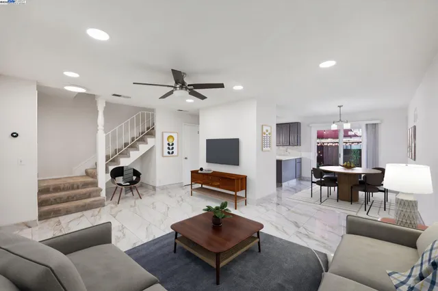 a living room with furniture and a flat screen tv with wooden floor