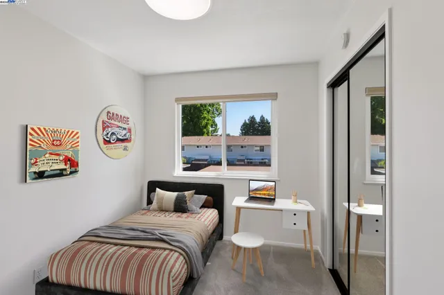 a bed room with a bed and a painting on the wall