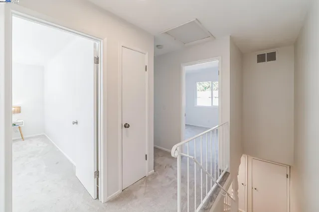 a view of a hallway with windows and stairs
