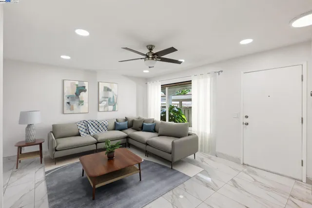 a living room with furniture and a ceiling fan
