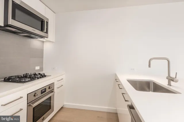 a kitchen with stainless steel appliances granite countertop a sink and a stove
