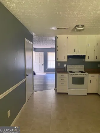 a view of a kitchen with stove and cabinets