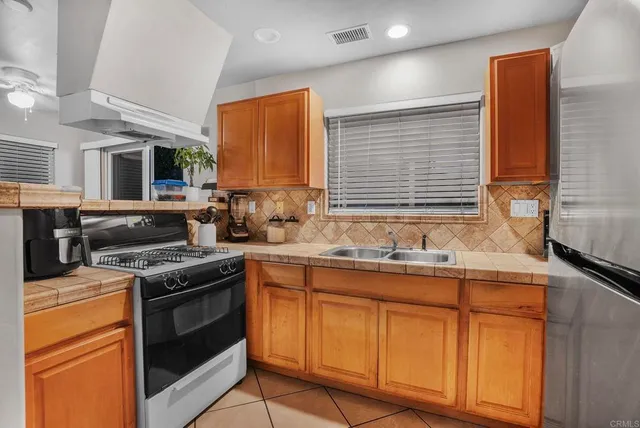 a view of a refrigerator in kitchen and a window