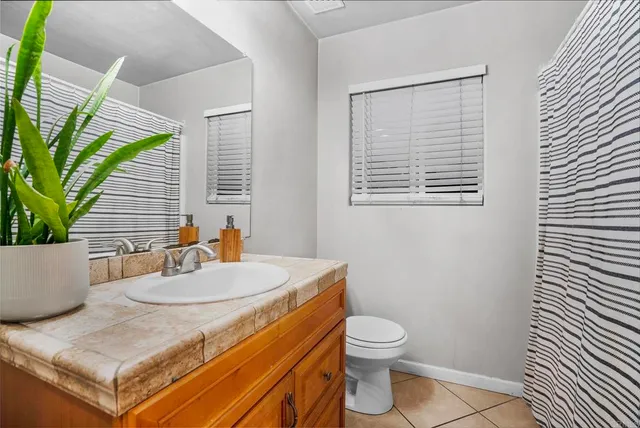 a bedroom with a bed and a flat tv screen on dresser