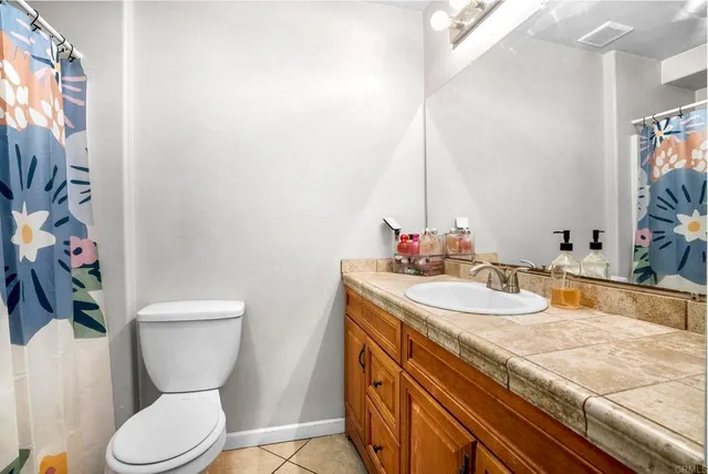 a view of a patio with couches table and chairs under an umbrella