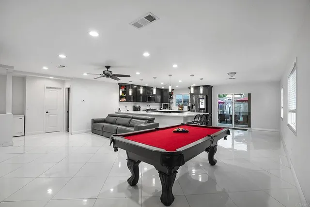 a kitchen with stainless steel appliances kitchen island granite countertop a refrigerator a stove a sink a dining table and chairs