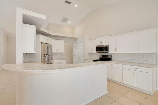 a kitchen with stainless steel appliances a refrigerator sink and white cabinets