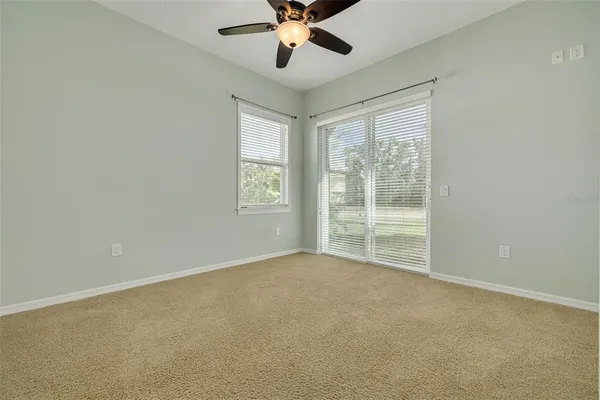 an empty room with a window and a fan