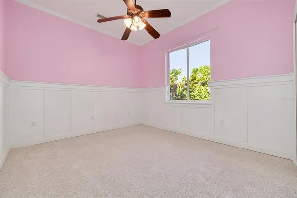 an empty room with a window and a ceiling fan