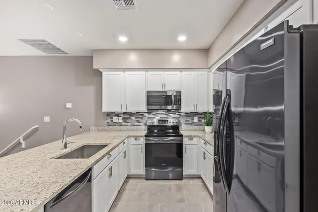 a kitchen with refrigerator and cabinets