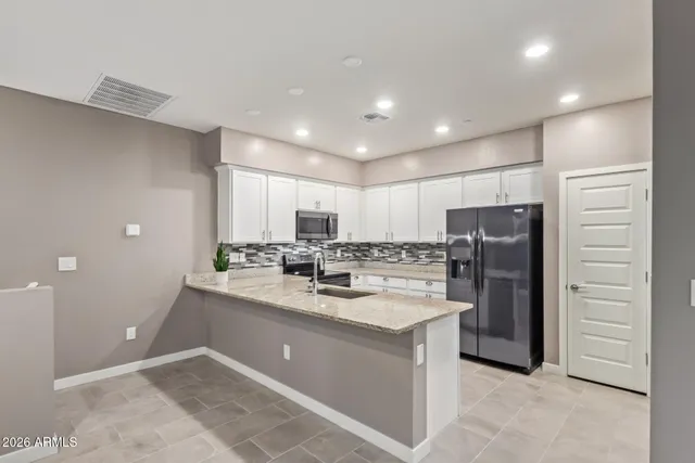 a kitchen with a granite countertop sink and natural light