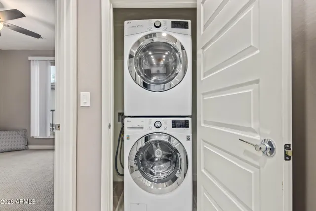 an empty room with ceiling fan and windows