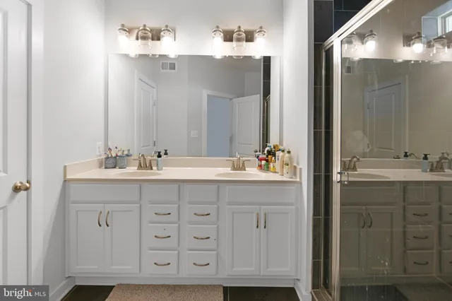 a bathroom with a double vanity sink mirror and