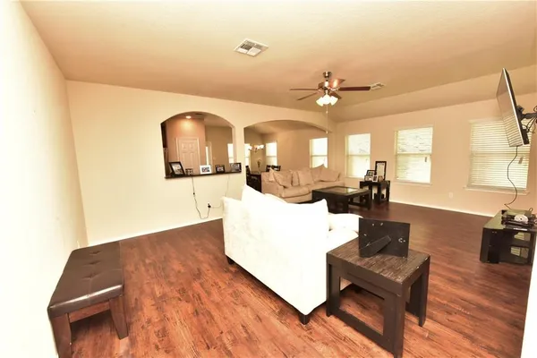 a living room with furniture and a wooden floor