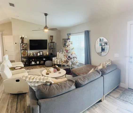 a living room with furniture a flat screen tv and a window